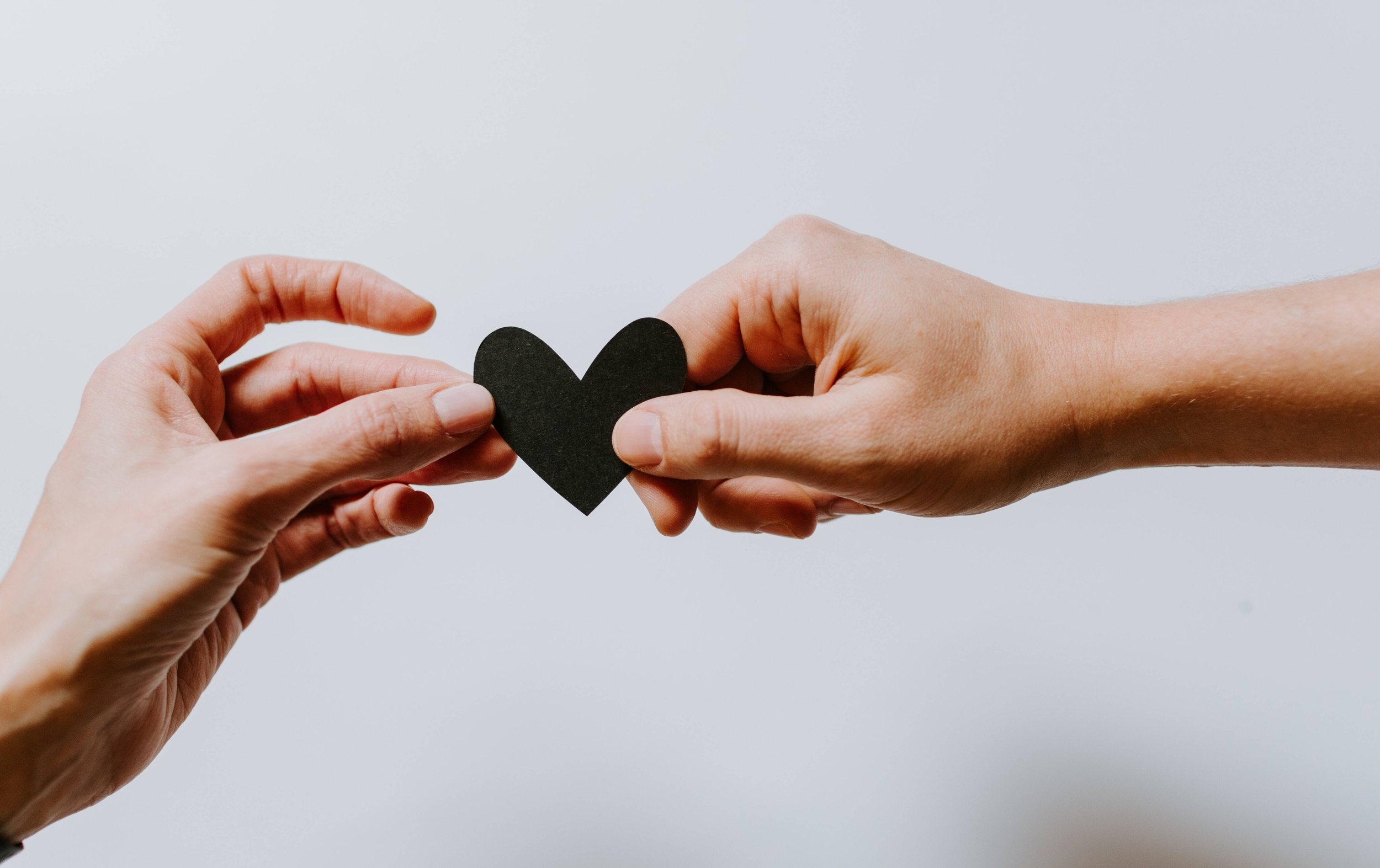 Mani che si avvicinano stringendo un cuore