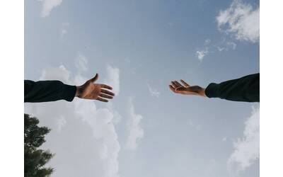 Immagine: Unione delle mani su sfondo cielo azzurro